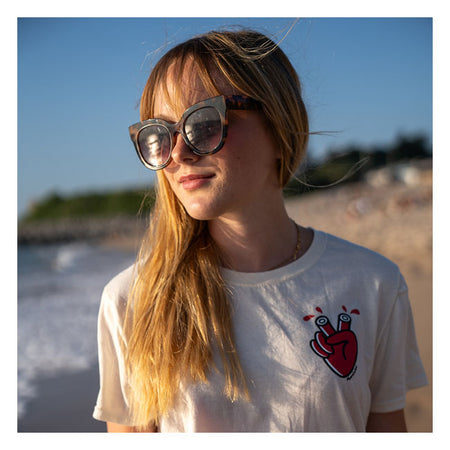 Ride Bold; Wear Loud with the Mamatee t-shirt from Holy Freedom; a fusion of edgy design and sustainable craftsmanship. Crafted from a soft and durable blend of 60% recycled cotton and 40% polyester; this t-shirt offers comfort that doesn''t compromise on eco-consciousness. Designed for a slim fit; the Mamatee features a classic crew-neck ensuring a silhouette that moves with you. The standout 3-color heart graphic adorns both the front and back. What truly sets the Mamatee apart is the exclusive artwork by